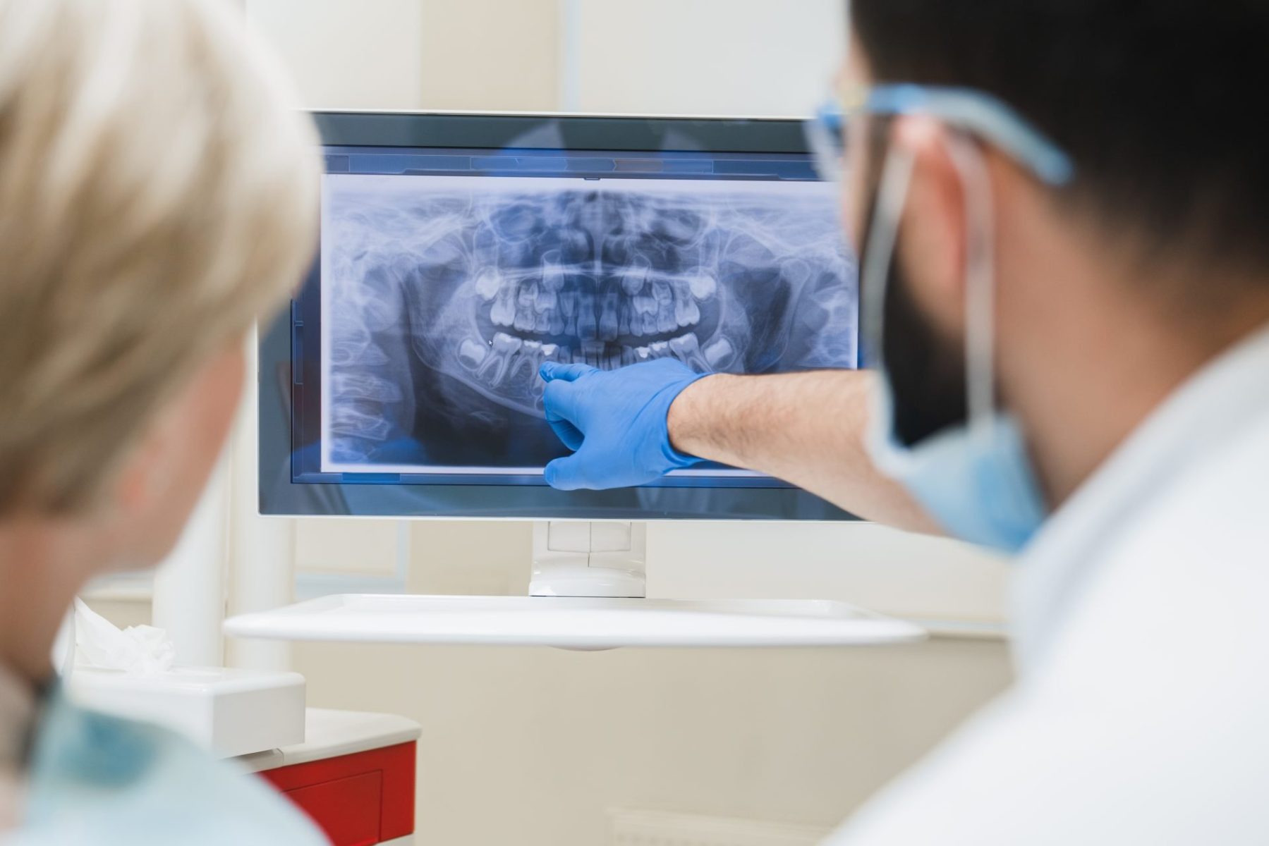 dentist-showing-explaining-an-x-ray-photo-of-jaws-2023-11-27-05-09-41-utc