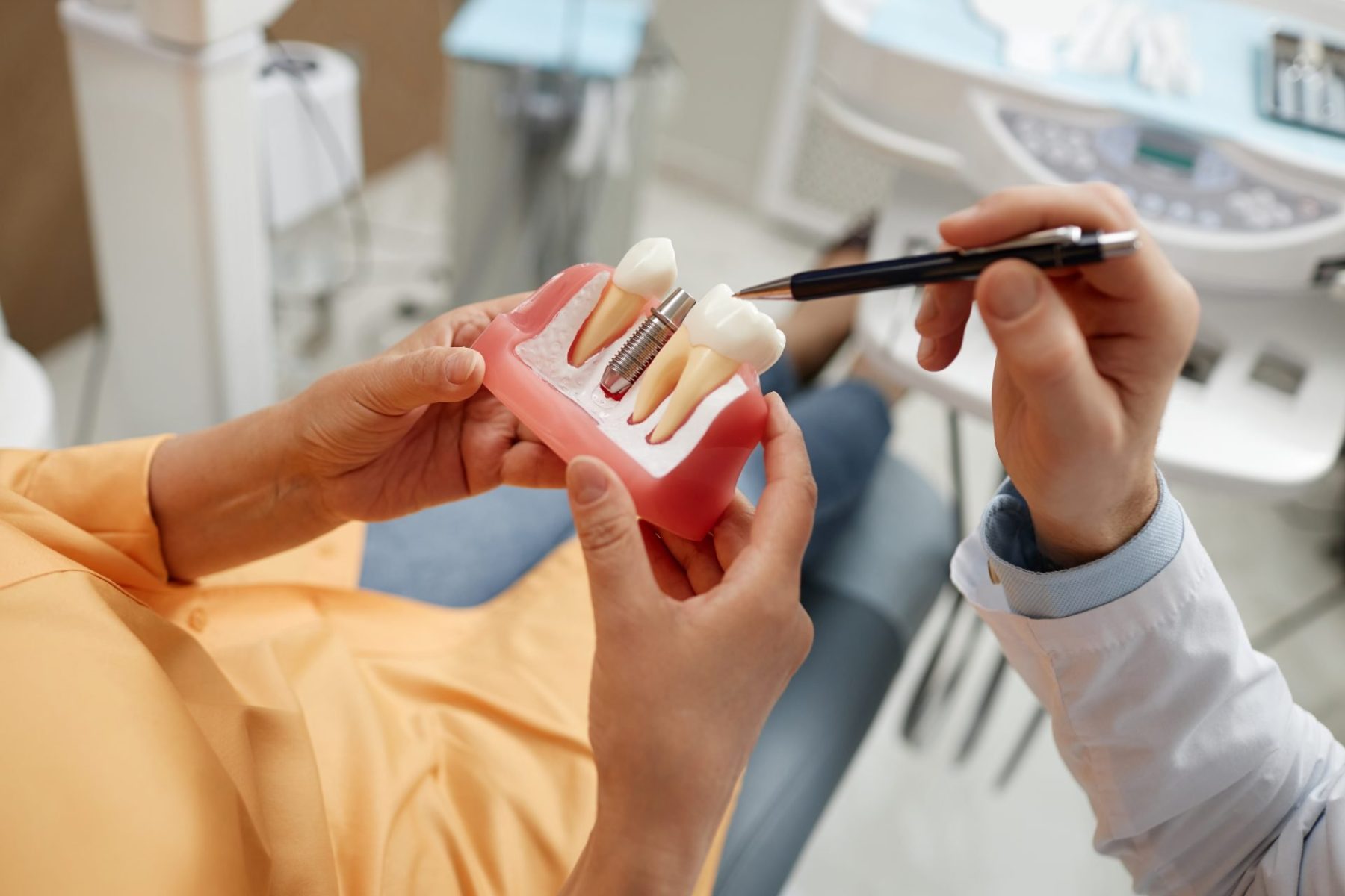 woman-holding-tooth-model-during-consultation-on-d-2023-11-27-05-27-44-utc